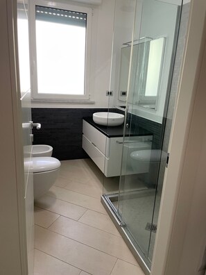 Een douche, een haardroger, een bidet, handdoeken