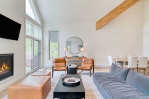 Cozy living room with a fireplace, leather armchairs, and a dining area.