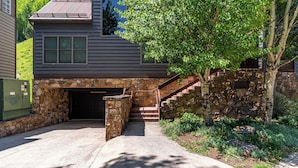 A house with a stone staircase leading to a garage, surrounded by greenery and a tree. - Etta Place 6 by AvantStay | Ski In/ Ski Out Unit! (Telluride)