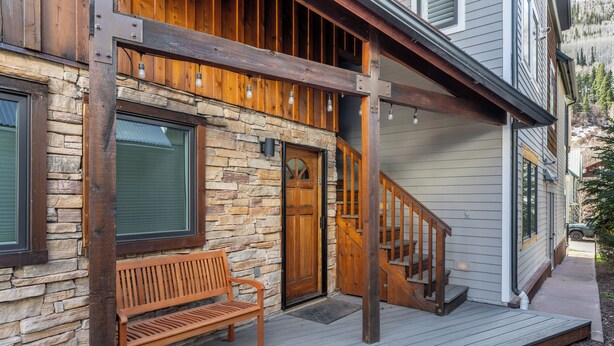 A wooden bench outside a building with a stone facade and a wooden staircase leading to a second floor. - Hruza Hideout by AvantStay | Walkable Location + Free Ski Shuttle, Mountain View (Telluride)