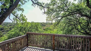 A wooden deck with a view of a forested landscape.