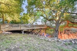 A wooden deck attached to a tree, surrounded by a rocky landscape and greenery. - Lux Ranch w/Hottub|AlamoSprings (Fredericksburg)