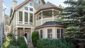 A two-story house with a bay window, a front porch, and a chimney. - Legacy House by AvantStay | Beautiful 4BDR Home in Great Location w/ Hot Tub (Telluride)