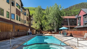 A swimming pool with a wooden deck, surrounded by buildings and trees. - Lulu City 5B by AvantStay | Across From Lift #7 | 10-minute Walk to Downtown (Telluride)