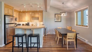 A modern kitchen with wooden cabinets, stainless steel appliances, and a central island with stools. - Lulu City 5B by AvantStay | Across From Lift #7 | 10-minute Walk to Downtown (Telluride)