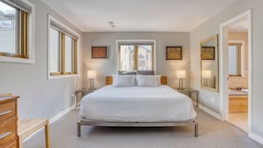 A bedroom with a large bed, bedside lamps, a dresser, and a window with blinds. - Lulu City 5B by AvantStay | Across From Lift #7 | 10-minute Walk to Downtown (Telluride)