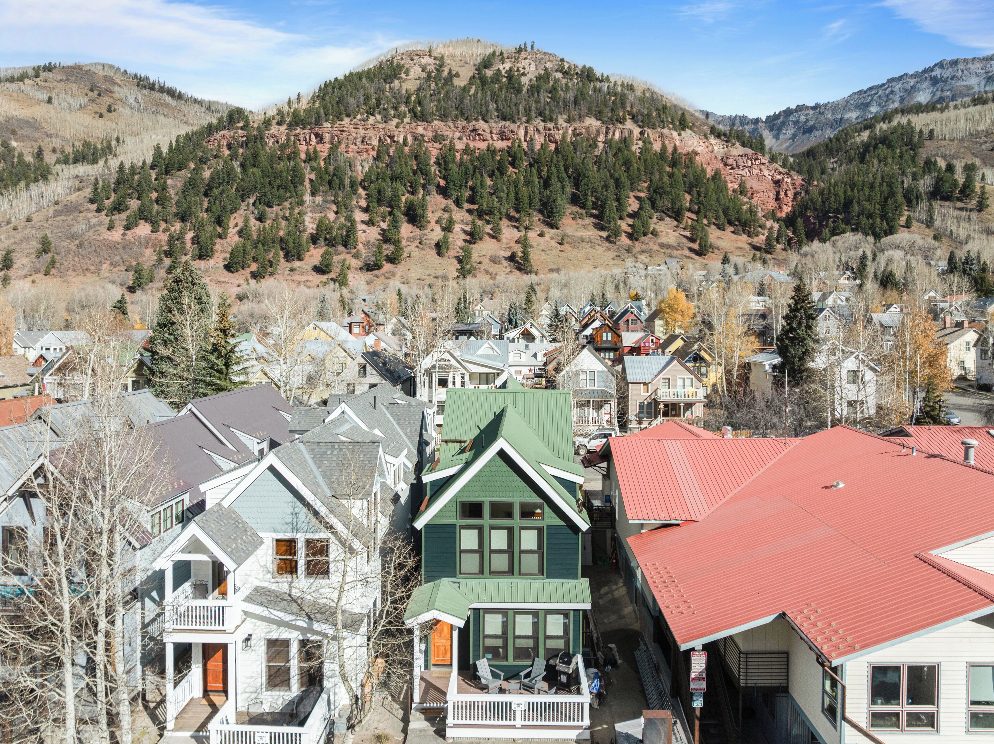 Un quartier résidentiel avec des maisons, dont certaines sont dotées de balcons, et une montagne en arrière-plan.