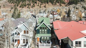 Un quartier résidentiel avec des maisons, dont certaines sont dotées de balcons, et une montagne en arrière-plan.