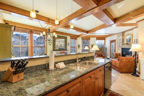 Enjoy cooking in this well-equipped kitchen with an oven, range hood, and large window offering a view of the surrounding landscape.