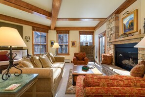 Relax in a warm and inviting living space with a comfortable sofa, armchairs, and a fireplace.