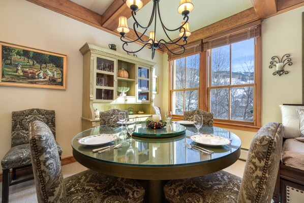 Enjoy meals in this stylish dining area with a round table for four, surrounded by comfortable chairs and a beautiful view.