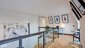 A modern interior with a staircase, glass railing, and artwork on the walls. - 3-bed Penthouse (London)