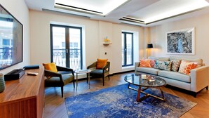 Una sala de estar moderna con un sofá, sillones, una mesa de centro y un televisor.