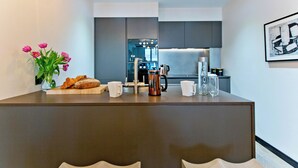 Una cocina moderna con una isla central, una cafetera y un jarrón de flores.