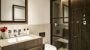 Un bagno moderno con uno specchio grande, due lavabi e zona doccia con pareti in vetro.