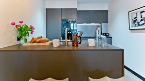Una cucina moderna con isola centrale, una macchina per il caffè e un vaso di fiori.
