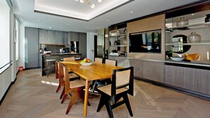 Une cuisine moderne avec une table et des chaises en bois, un four encastré et une grande fenêtre.