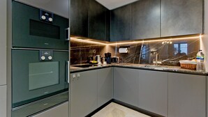 Eine moderne Küche mit eingebauten Geräten, einer Marmor-Spritzschutzwand und einem eleganten Design.