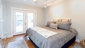 A bedroom with a bed, a ceiling fan, a door, and a window. - Viking Lodge 103 by AvantStay | Stunning Condo, Near Ski Lift (Telluride)