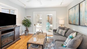 A living room with a flat-screen TV, wooden coffee table, grey sofa, and a ceiling fan. - Viking Lodge 103 by AvantStay | Stunning Condo, Near Ski Lift (Telluride)