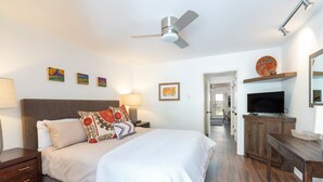 A bedroom with a bed, nightstands, a TV, and a ceiling fan. - Viking Lodge 216 by AvantStay | Great Ski Access, Walk to Downtown (Telluride)