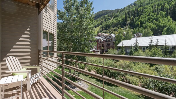 A balcony with a view of a mountainous landscape, wooden deck, and two Adirondack chairs. - Viking Lodge 216 by AvantStay | Great Ski Access, Walk to Downtown (Telluride)