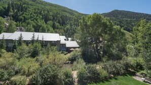 A building with a metal roof, surrounded by dense forest and hills. - Viking Lodge 216 by AvantStay | Great Ski Access, Walk to Downtown (Telluride)