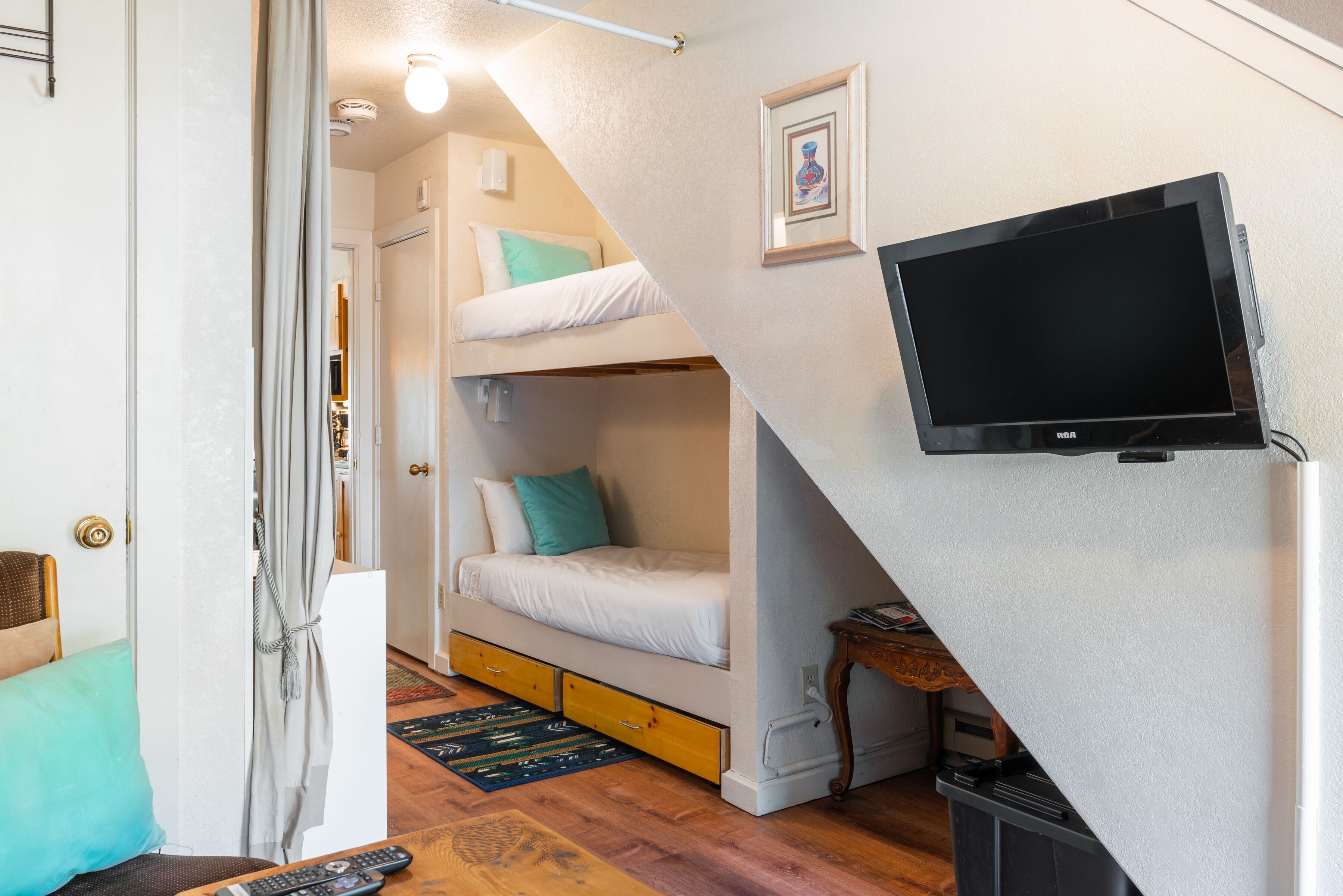 A compact room with bunk beds, a television, and a small table.