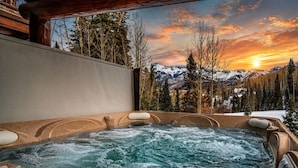 Un bain à remous avec une vue sur les montagnes et un coucher de soleil.