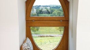 Una habitación con ventana integrada que ofrece vistas a un paisaje verde.