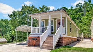 A single-story house with a porch, a front door, and a staircase leading to the entrance. - *Cottage #3 @ Fisherman's Landing (boat shelter)* (Langston)
