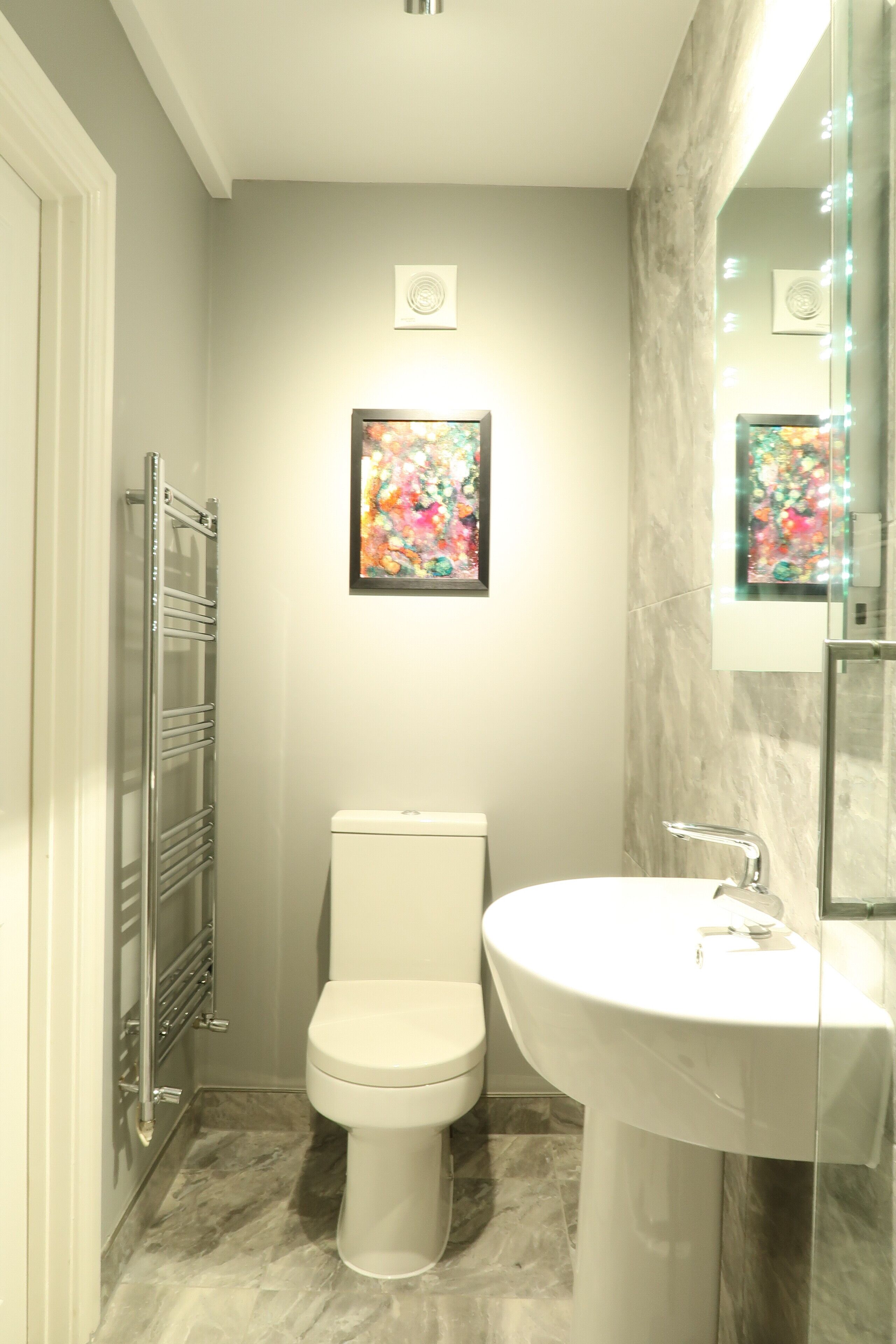 A bathroom with a toilet, a sink, and a shower.