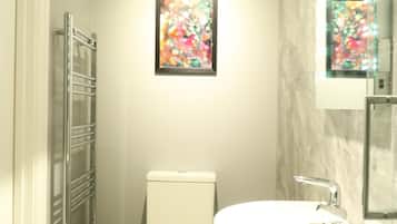 A bathroom with a toilet, a sink, and a shower.