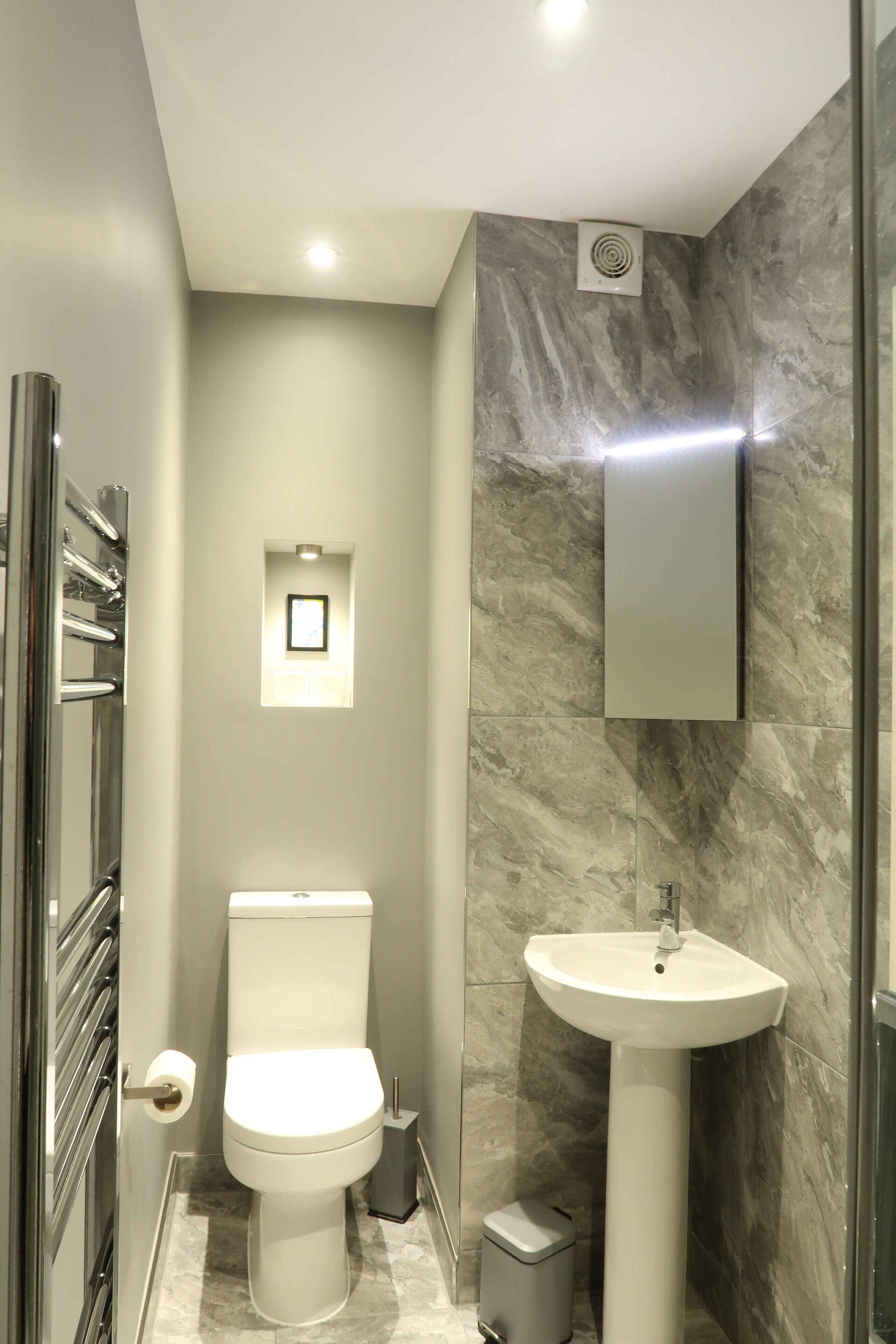 Une salle de bain moderne avec des toilettes, un lavabo et une petite fenêtre.