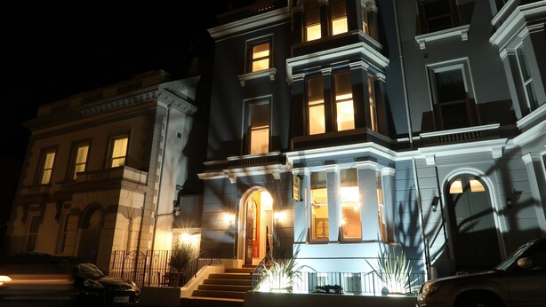 A multi-story building with illuminated windows and a grand entrance. - The Craft House (Plymouth)