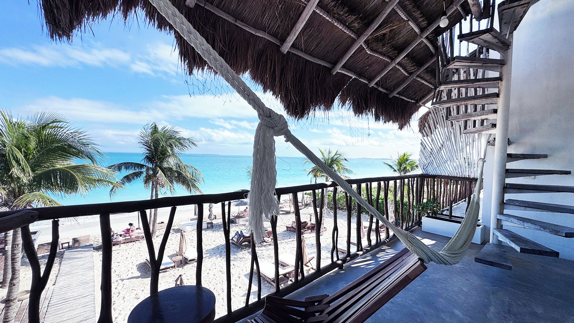 A balcony with a view of a beach and the ocean.
