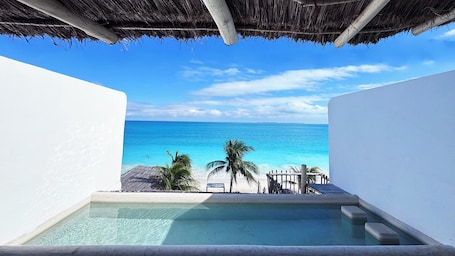 A pool with a view of the ocean and palm trees.
