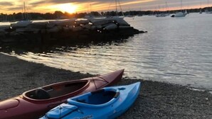 A marina with boats docked at the shore during sunset. - Adorable Tiny House in Picturesque Seaside Village (Warren)