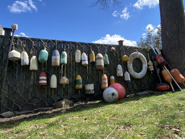 A collection of buoys and a netted fence against a clear sky.