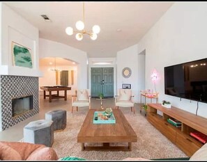 Relax in this stylish living room with a sofa, armchairs, and a fireplace.