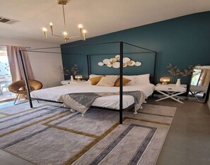 Relax in a stylish bedroom with a four-poster canopy bed, a plush chair, and a comfortable reading nook.