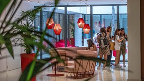 A modern interior with a glass wall, red pendant lights, and a seating area with a table and chairs. - The Boc Hostels City - Youth Hostel (Palma de Mallorca)