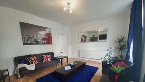 Un salon avec un canapé, une table basse et un tapis bleu.