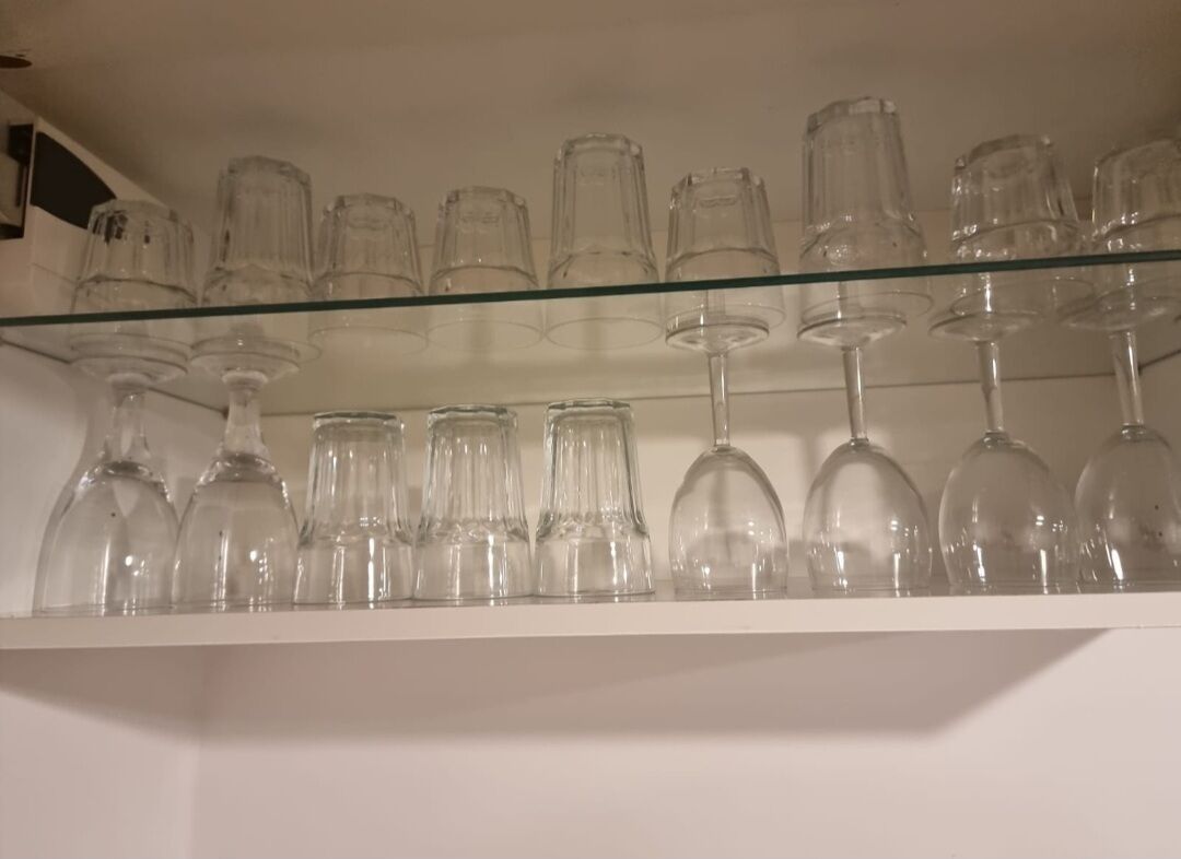 A glass shelf with various wine glasses and tumblers.