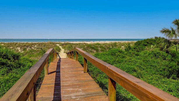 A wooden boardwalk leading to a beach with clear skies. - Ocean Views with Easy access to pools and beach (Tybee Island)
