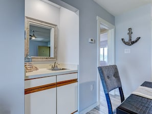 A bathroom with a sink, mirror, and towel rack.