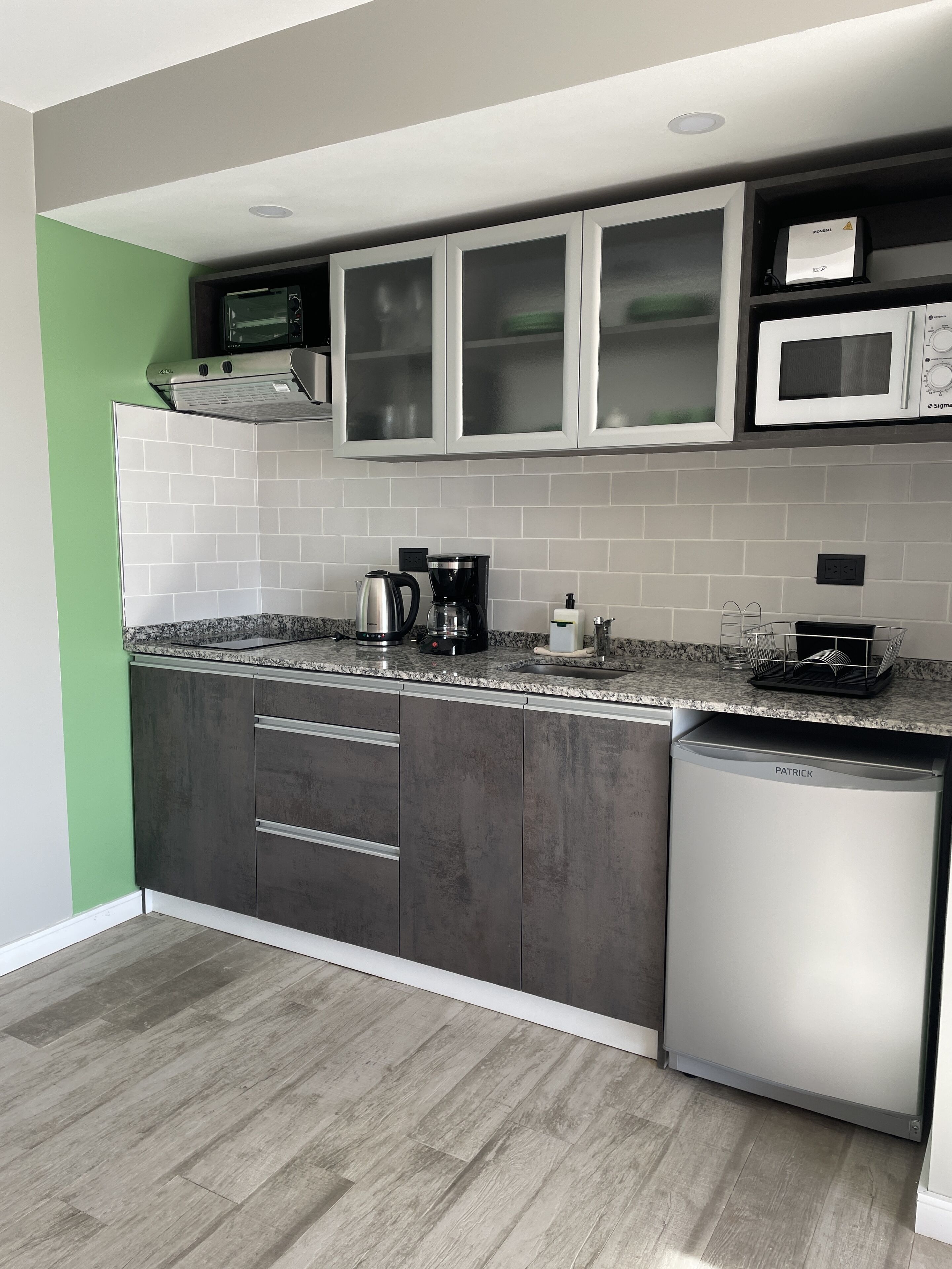 Una cocina moderna con lavavajillas, microondas y cafetera sobre la encimera.