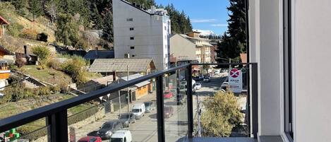 Un balcón con vista a un estacionamiento y edificios.