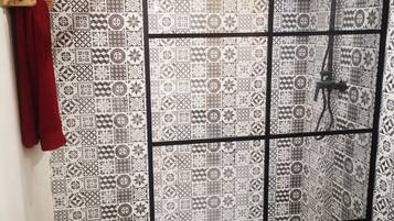 Een bad/douchecombinatie, een haardroger, handdoeken, zeep