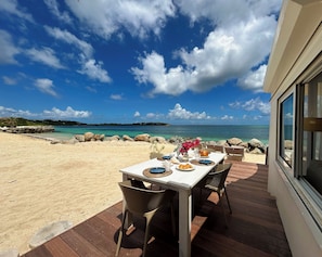 A table set on a deck with a view of the ocean and a clear sky.
